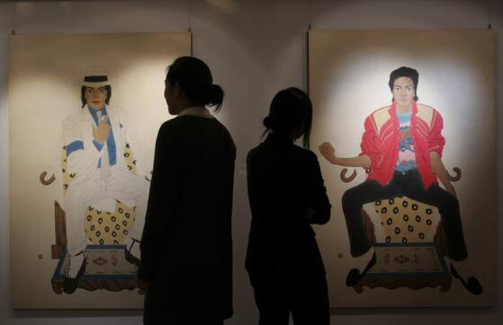 Staff members of Seoul Auction poses in front of "Portrait of the King" depicting the late pop star Michael Jackson during a private sales exhibition in Hong Kong -0051POH5.JPG-